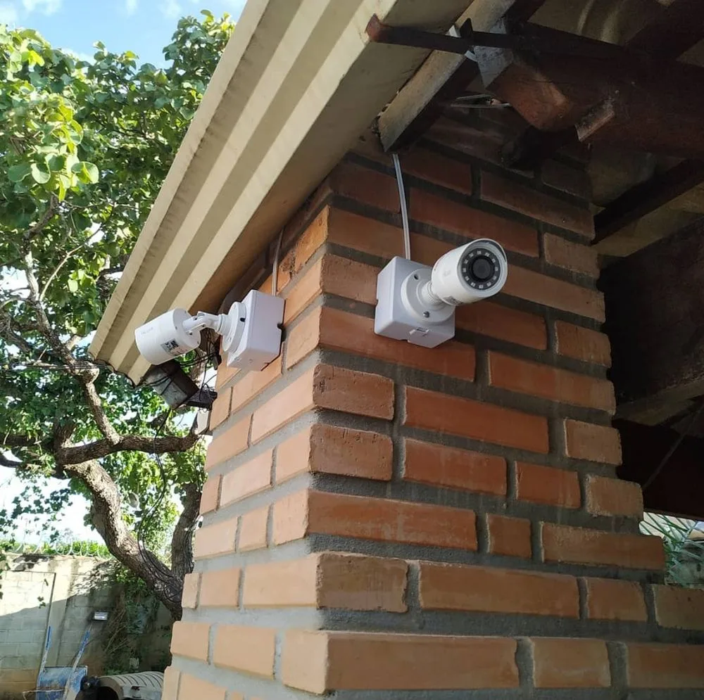 Câmera CFTV instalada em parede, detalhe da lente